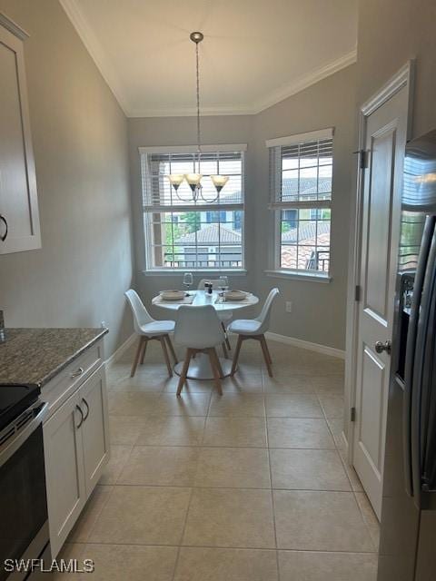 dining room with crown molding, a chandelier, baseboards, and light tile patterned floors