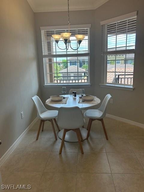 dining area with ornamental molding, plenty of natural light, a chandelier, light tile patterned flooring, and baseboards
