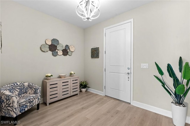 entryway featuring light wood-style floors, baseboards, and an inviting chandelier