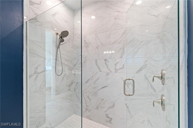 bathroom featuring a marble finish shower