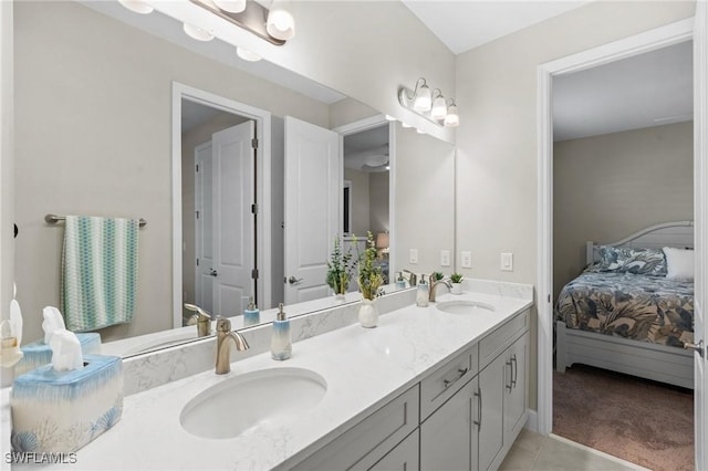 ensuite bathroom featuring ensuite bathroom, double vanity, tile patterned flooring, and a sink