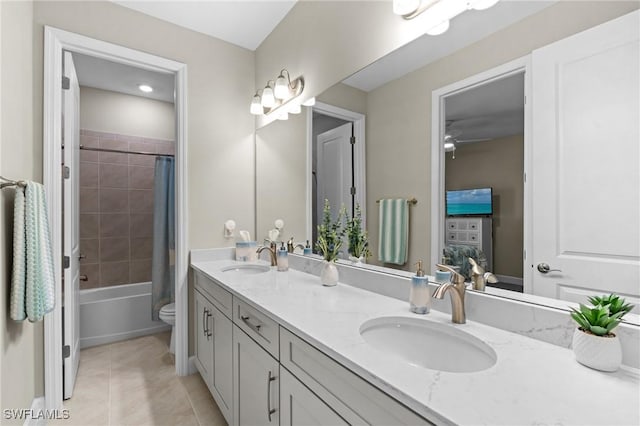 bathroom featuring shower / tub combo with curtain, double vanity, a sink, and tile patterned floors