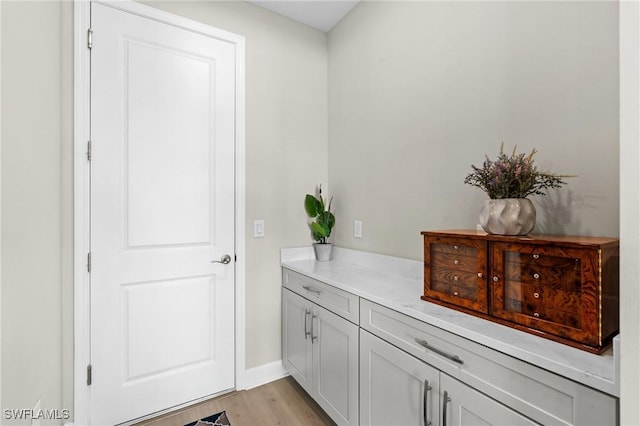 entryway with light wood-style flooring and baseboards