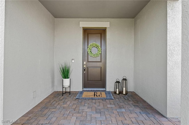 doorway to property featuring stucco siding