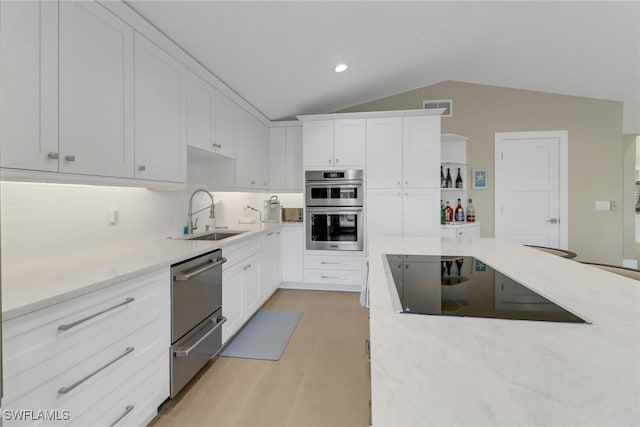 kitchen featuring a warming drawer, double oven, white cabinets, a sink, and black electric cooktop