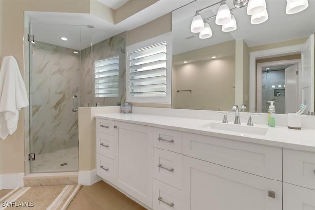 bathroom featuring tile patterned floors, a marble finish shower, and vanity