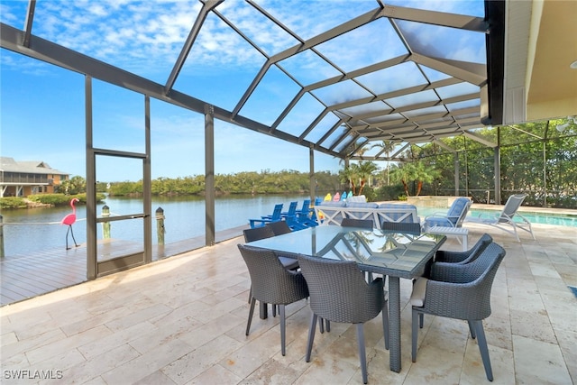 view of patio with a water view, glass enclosure, outdoor dining area, and an outdoor pool