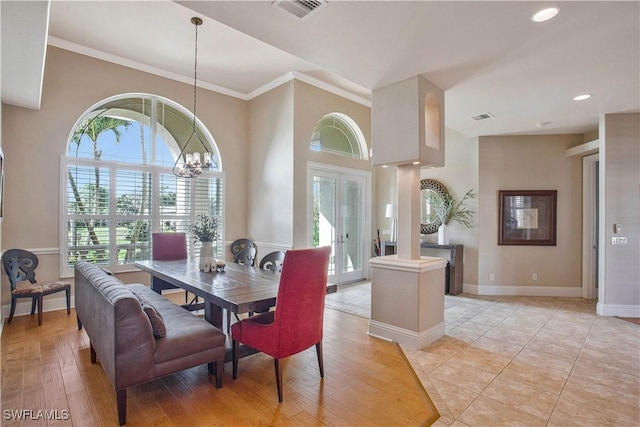 dining room featuring baseboards, visible vents, a chandelier, and french doors