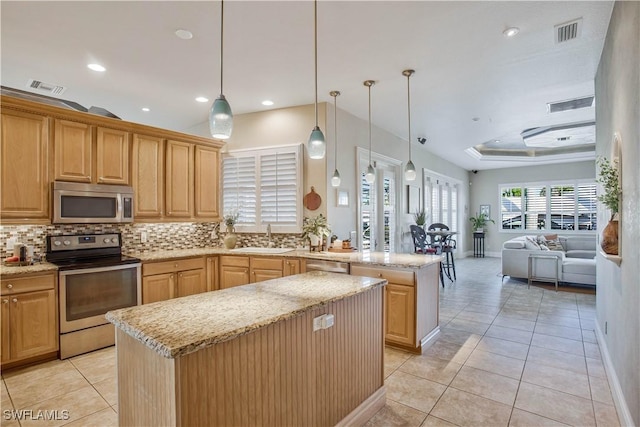 kitchen featuring stainless steel appliances, a sink, a kitchen island, open floor plan, and pendant lighting