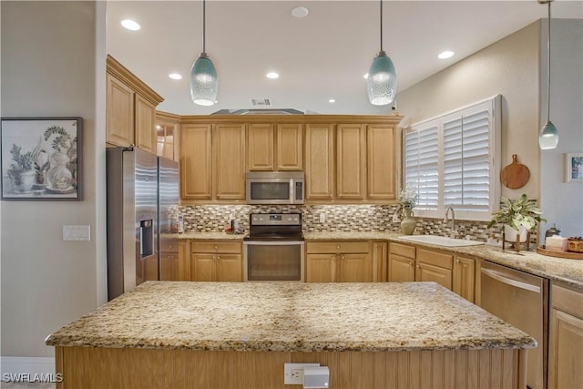 kitchen featuring a center island, tasteful backsplash, hanging light fixtures, appliances with stainless steel finishes, and a sink