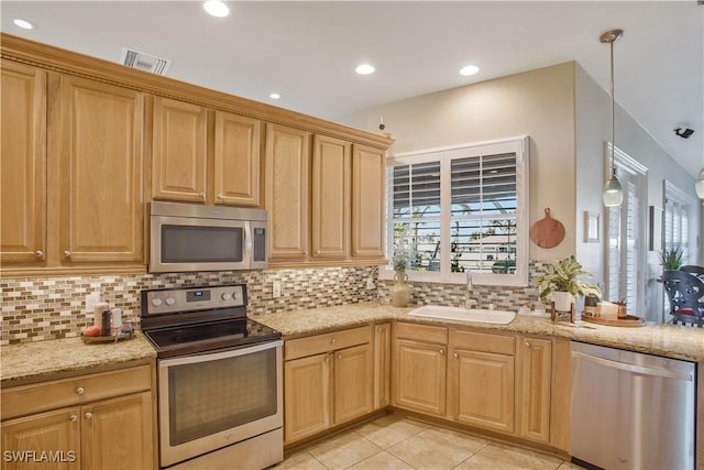 kitchen featuring light tile patterned floors, stainless steel appliances, a sink, tasteful backsplash, and decorative light fixtures