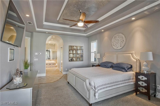 carpeted bedroom with arched walkways, recessed lighting, visible vents, baseboards, and a raised ceiling