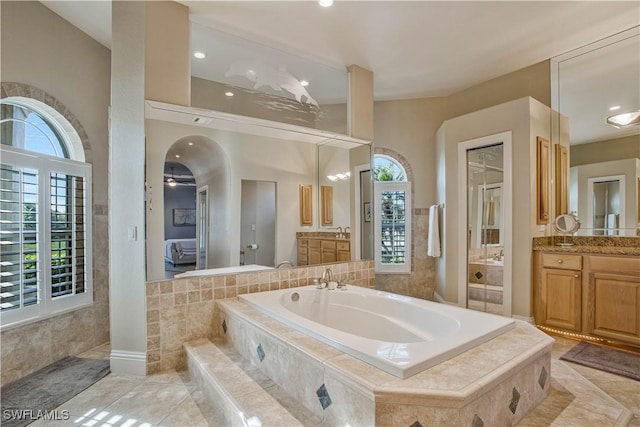 bathroom featuring a healthy amount of sunlight, ensuite bath, and vanity