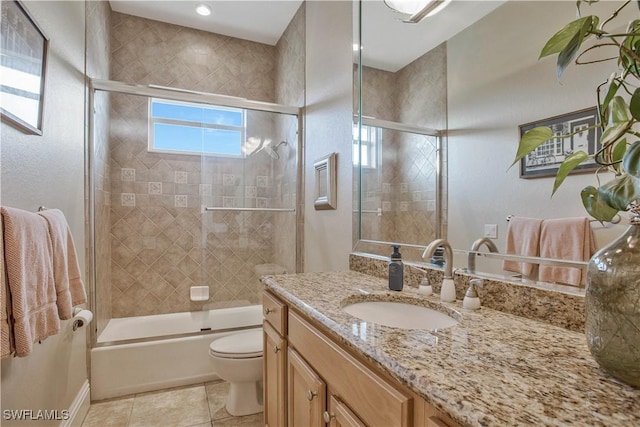 bathroom featuring toilet, tile patterned flooring, enclosed tub / shower combo, and vanity