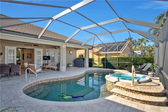 view of swimming pool with glass enclosure, ceiling fan, a patio area, a pool with connected hot tub, and an outdoor living space