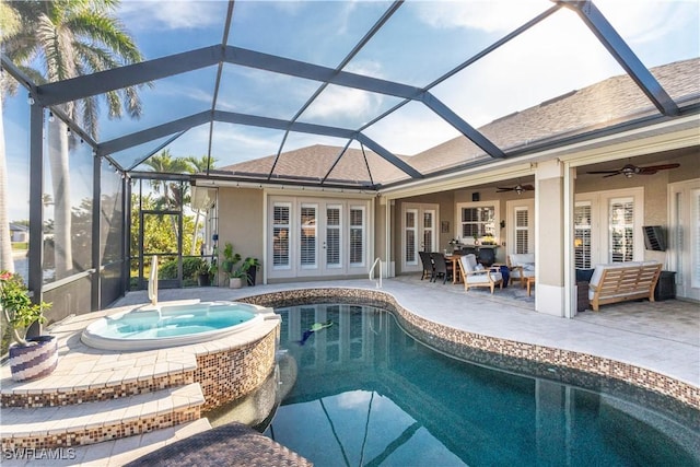 view of pool with a pool with connected hot tub, a ceiling fan, a patio area, a lanai, and an outdoor living space