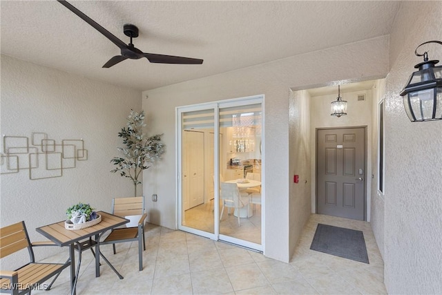 dining area featuring a ceiling fan and a textured wall