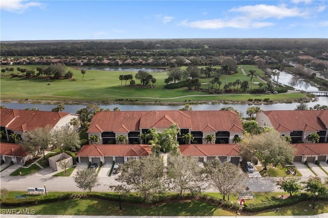 drone / aerial view featuring golf course view and a water view