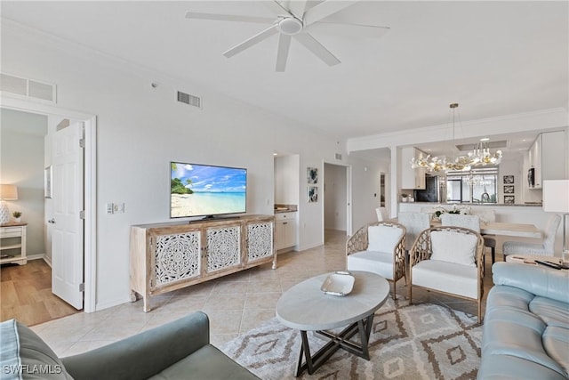 living area with light tile patterned floors, ceiling fan with notable chandelier, visible vents, and crown molding