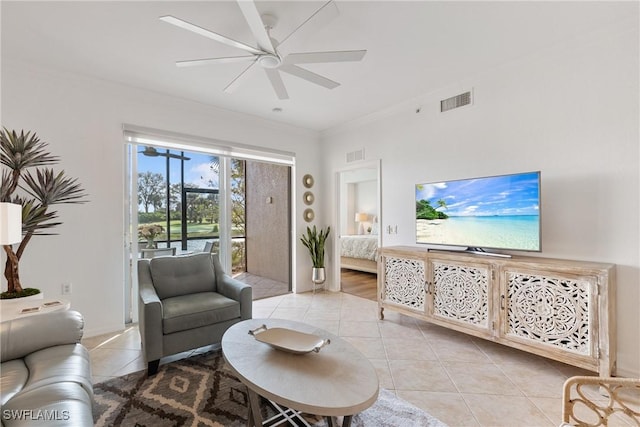 living area with ornamental molding, light tile patterned flooring, visible vents, and a ceiling fan