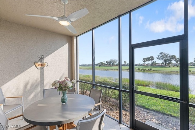 sunroom with a water view, plenty of natural light, and a ceiling fan