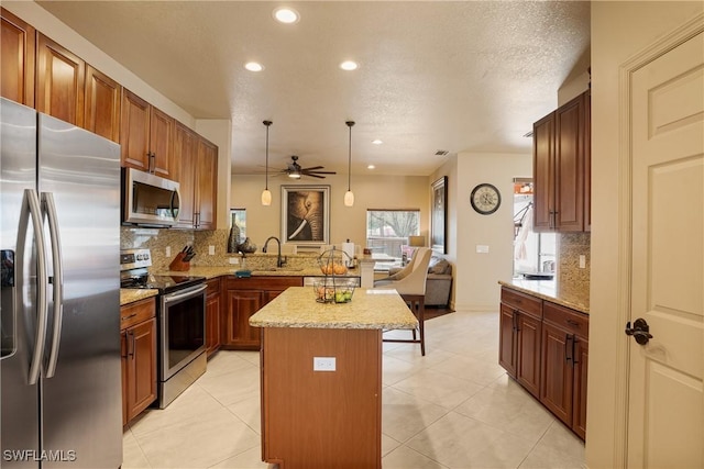 kitchen with appliances with stainless steel finishes, a center island, a sink, pendant lighting, and backsplash