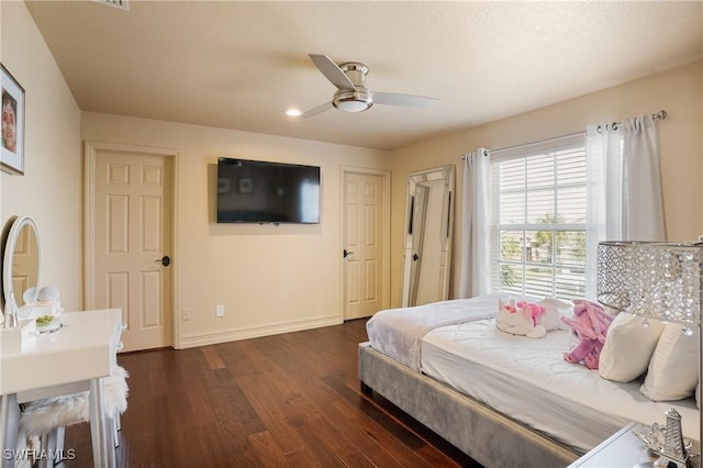 bedroom featuring ceiling fan, dark wood-style flooring, and baseboards