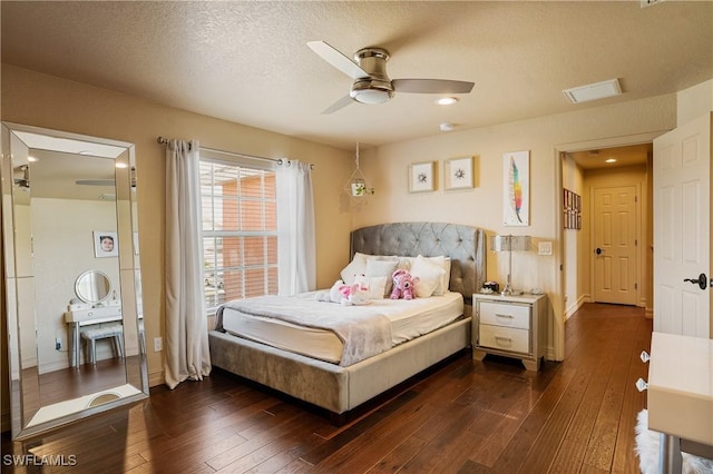 bedroom featuring visible vents, dark wood-type flooring, ceiling fan, a textured ceiling, and baseboards