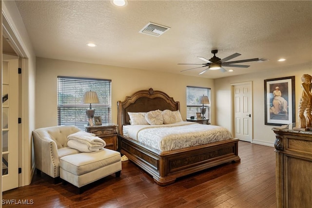 bedroom featuring visible vents, dark wood finished floors, and a textured ceiling