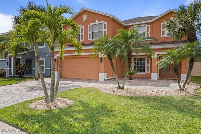 view of front of home featuring a front lawn, decorative driveway, and stucco siding