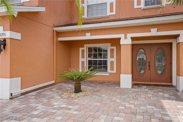 entrance to property featuring stucco siding