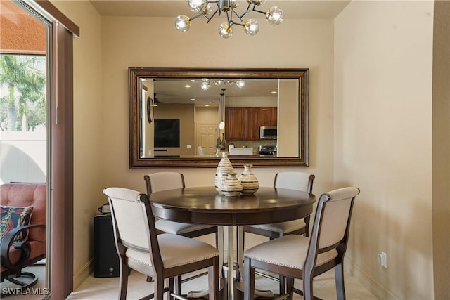 dining space featuring an inviting chandelier and baseboards