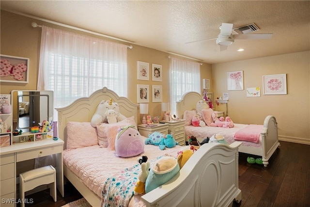 bedroom featuring baseboards, visible vents, dark wood finished floors, ceiling fan, and a textured ceiling