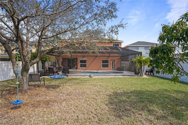 back of house with a lawn, a fenced in pool, a lanai, fence, and stucco siding