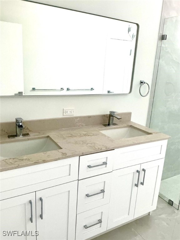 full bath featuring a sink, a shower stall, and double vanity