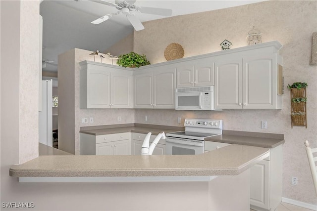 kitchen featuring white appliances, white cabinetry, ceiling fan, and a peninsula