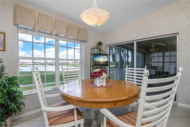 dining area with tile patterned flooring and vaulted ceiling