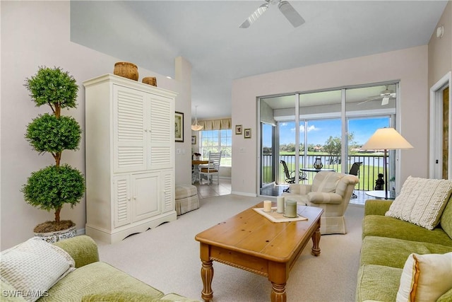 living room featuring light carpet, a ceiling fan, and baseboards