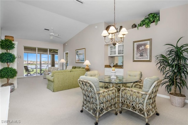 carpeted dining room with lofted ceiling, baseboards, and ceiling fan with notable chandelier