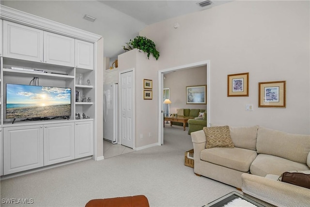 living area with light carpet, baseboards, visible vents, and vaulted ceiling