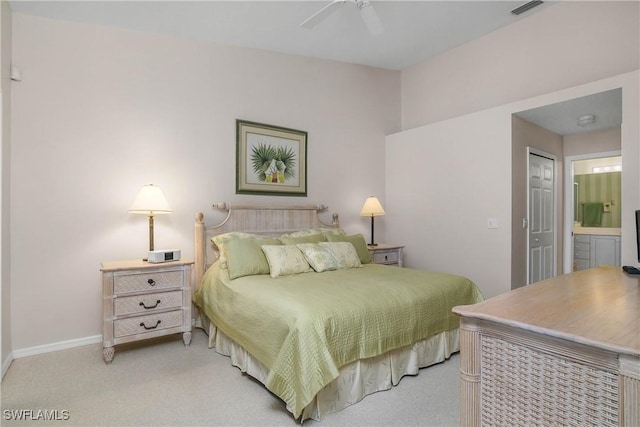 bedroom featuring baseboards, light carpet, visible vents, and ensuite bath