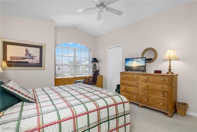 bedroom with lofted ceiling, a ceiling fan, a closet, and light colored carpet