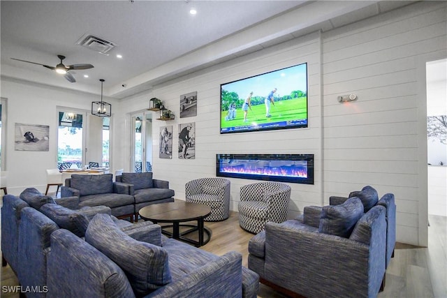 living area featuring recessed lighting, visible vents, light wood-style floors, a glass covered fireplace, and ceiling fan