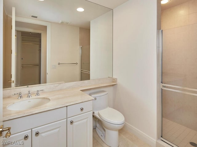 bathroom featuring toilet, vanity, visible vents, baseboards, and a stall shower