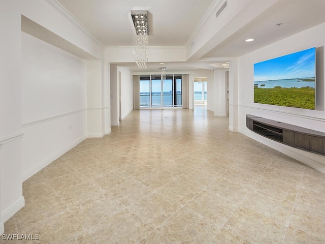 unfurnished living room featuring baseboards, ornamental molding, visible vents, and a notable chandelier