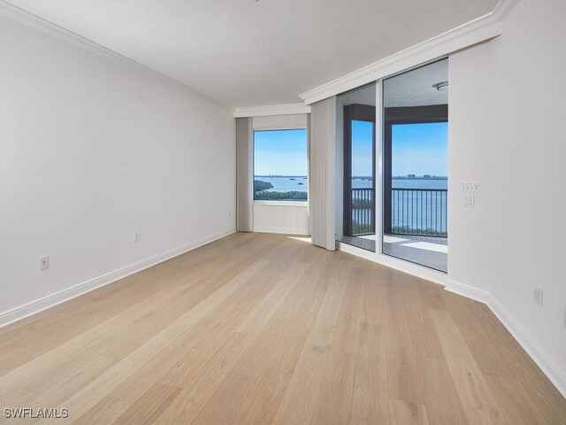 unfurnished room with baseboards, light wood finished floors, and crown molding