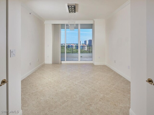 spare room with a city view, baseboards, a wall of windows, and crown molding