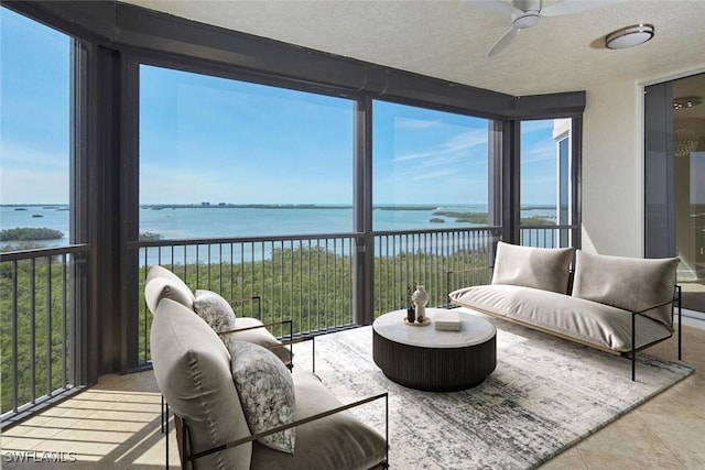 sunroom / solarium featuring a water view, a wealth of natural light, and a ceiling fan