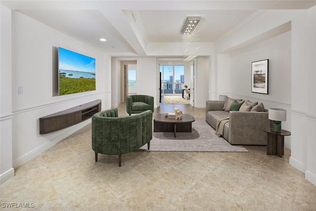 living area with baseboards and crown molding