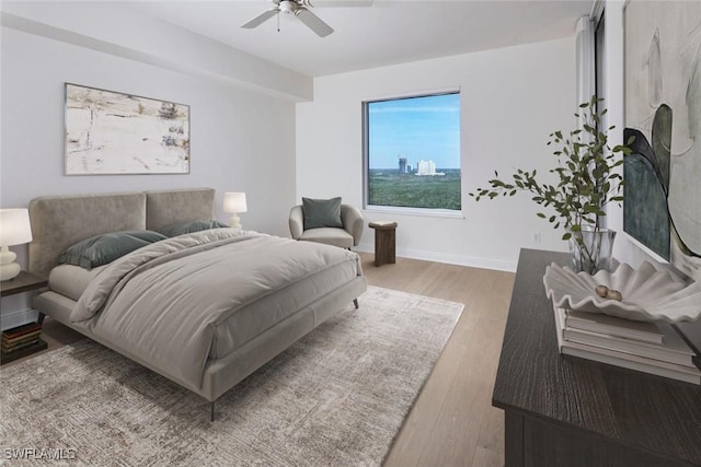 bedroom featuring wood finished floors, a ceiling fan, and baseboards